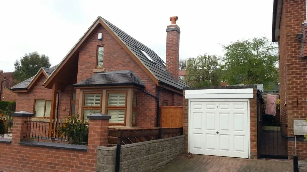 Modern house with a new pitched roof, Velux window, and chimney