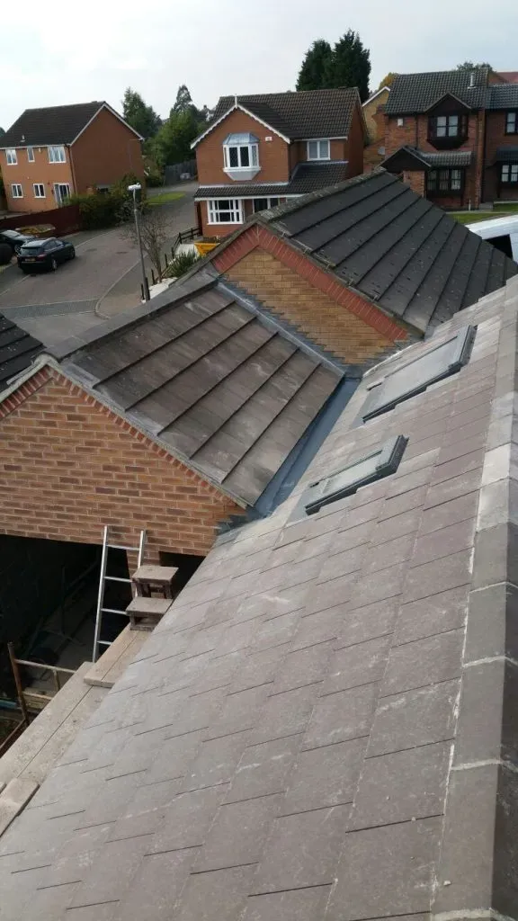 Pitched roof with grey tiles, leadwork, and two Velux windows installed.