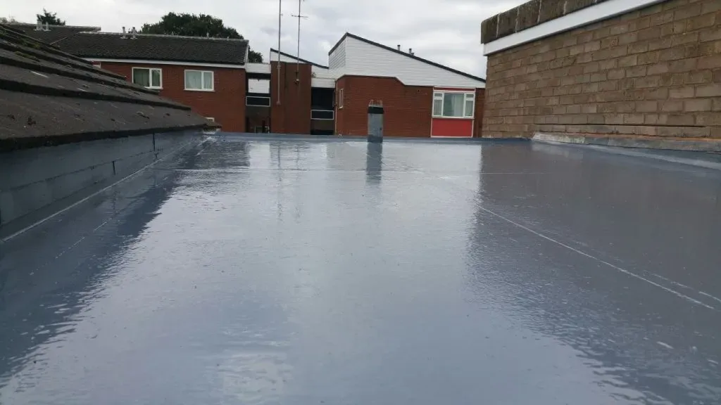 A modern, grey liquid waterproof coating applied to a flat roof, providing a seamless and durable finish.